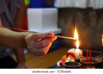 Hand Of A Woman Light The Incense Sticks At Home (fire On The Candle And Incense Sticks)