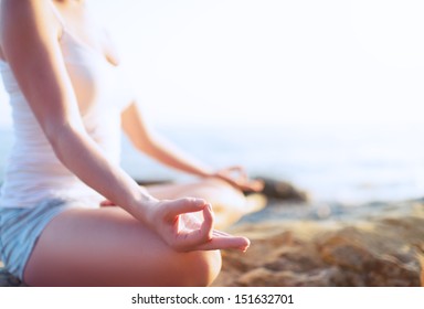 hand of a woman meditating in a yoga pose on the beach - Powered by Shutterstock