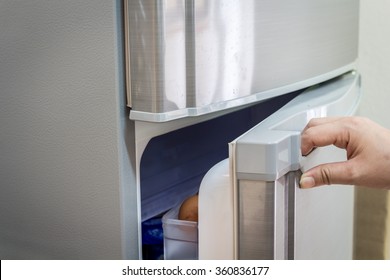 Hand A Woman Is Opening A Refrigerator Door