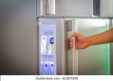 Hand A Woman Is Opening A Refrigerator Door