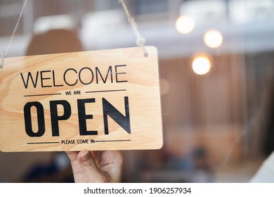 Hand Of Woman Owner Retail,coffee Shop Woman Turning Sign Board To Open With Wearing Face Mask ,protection To Pandemic Of Coronavirus Reopen Store,restaurant After Close Lockdown Quarantine In Covid.