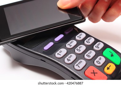 Hand Of Woman Paying With NFC Technology On Mobile Phone, Credit Card Reader, Payment Terminal, Finance Concept