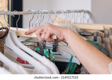 Hand Of A Woman Picking Up A Clothes From A Hanger In A Fashion Shop. Shopping Concept.