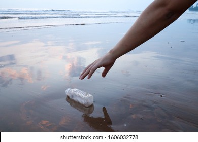 Hand Woman Picking Up Plastic Bottle Cleaning On The Beach 
