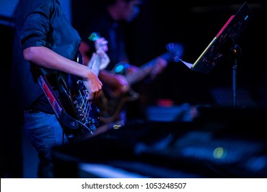 Hand Of A Woman Playing Bass Guitar.