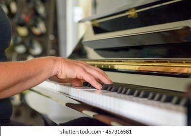Hand of a woman playing the piano indoors at home in a close up view conceptual of a musical hobby, entertainment or classical recital