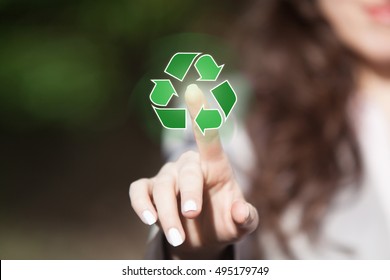 Hand of woman pressing recycling symbol on virtual touch screen. Environmental concept recycle - reduce - reuse. - Powered by Shutterstock