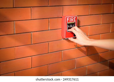 The Hand Of Woman Is Pulling Fire Alarm On The Brick Wall