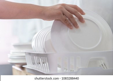 Hand Of Woman Putting Just Washed Clean Plate In The Dish Rack