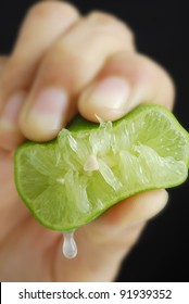 Hand of a woman squeezing a green lime
