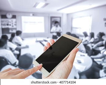 Hand Of Woman Turn Off Smart Phone On Blur Photo Of Business People In The Meeting Room