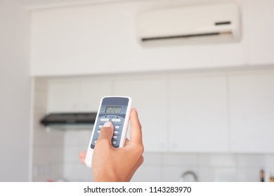 Hand of the woman turning on air conditioning - Shutterstock ID 1143283970