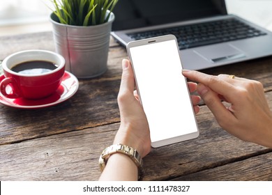 hand woman using a telephone, empty screen smart phone and computer on wooden table top view. with clipping path