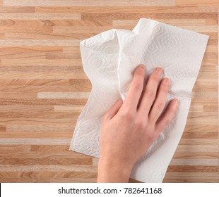 Hand Of Woman Wiping Wooden Surface With Paper Towel