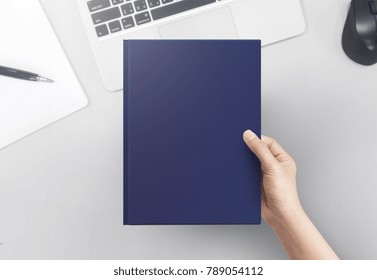 Hand Women Holding Book Cover Blank On Office Table Top View.  Blank Book Cover.