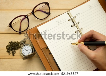 hand of women writting on diary book