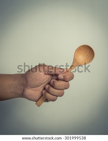 Hand with woodenspoon. Cooking concept