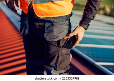 Hand Of A Worker Answering The Phone Charged By Alternative Energy From A Pocket.