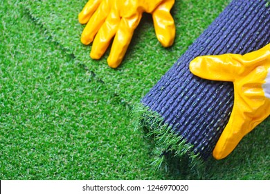 Hand Of A Worker In Gloves With A Artificial Lawn Grass. Artificial Turf Laying Process. 