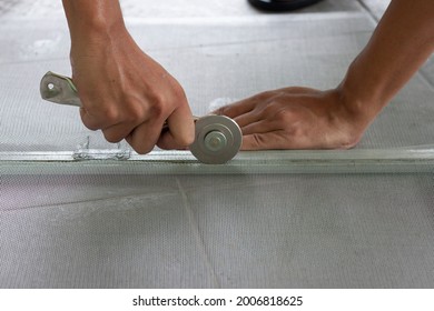 Hand Of Worker Holding A Wheel Tool To Install A Aluminum Mosquito Net Wire Mesh Screen This Is To Be Attached To The Window Of The House To Prevent Insects.