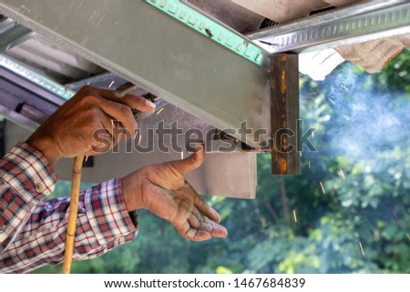 Hand of worker or Laborer uses electric welding device