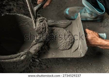Hand worker mix cement plaster construction house site background, Person work concrete industry job, hand holding trowel equipment with Mortar cement plastering   
