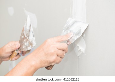 Hand Of Worker With Plaster And Trowel To Gypsum Board