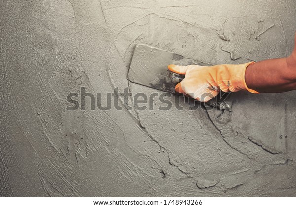 hand of worker plastering cement at wall for\
building house