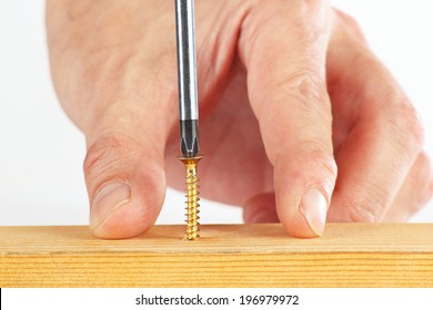 Hand Of The Worker Screws In A Wooden Block With A Screwdriver