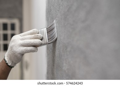 Hand Of Worker Use Brush For Color Paint Concrete Loft Style On Wall