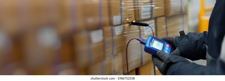 Hand of worker using thermometer to temperature measurement in the goods boxes with ready meals after import in the cold room or warehouse for keep temperature room, Logistics Banner with copy space