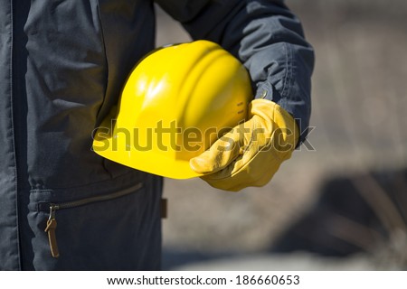 hand of worker with yellow hard-hat,natural light
