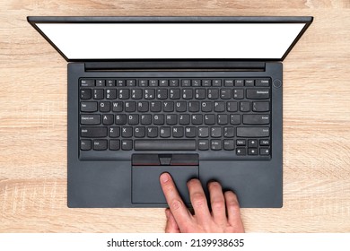 Hand working on a computer touchpad. A man is working by using a laptop computer on  wooden table.  Top view, business office workplace