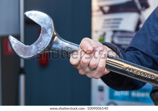 Hand with wrench. Auto mechanic in car repair.\
Tool wrench for repair.
