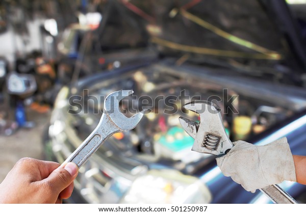 Hand with wrench\
Car\'s mechanic checking 