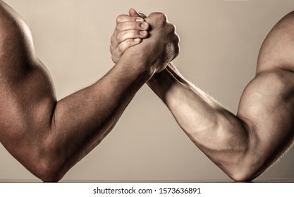 Hand wrestling, compete. Hands or arms of man. Muscular hand. Clasped arm wrestling. Two men arm wrestling. Rivalry, closeup of male arm wrestling. Muscular men measuring forces, arms. - Shutterstock ID 1573636891