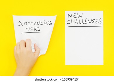 Hand Wrinkles A Piece Of Paper With Phrase: Outstanding Tasks, And Nearby Blank Sheet Of Paper With Phrase: New Challenges. The Concept Of Setting New Goals, And Recognition Of Outstanding Tasks.