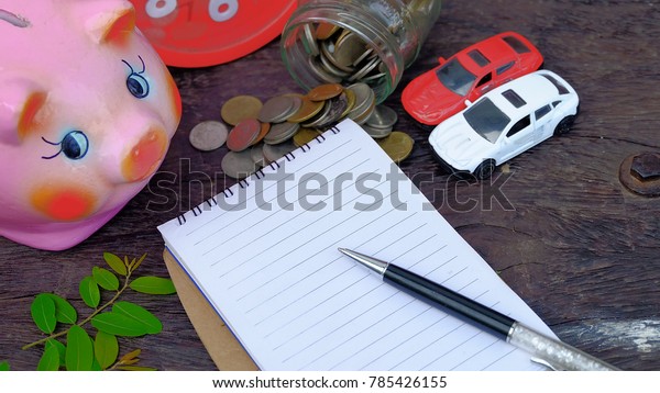 Hand write wish list on notepad with\
coins,car key,piggy bank,car toy.money\
themes.