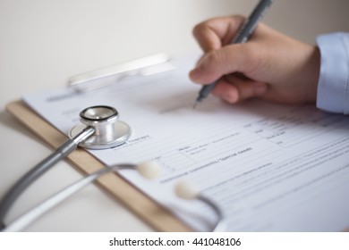 Hand Writing Blank Patient Information Form With Stethoscope.