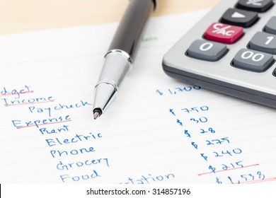 Hand Writing Home Budget With Calculator