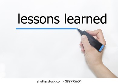 Hand writing lessons learned with blue marker on transparent wipe board.