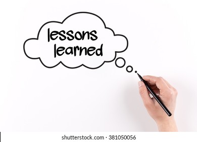 Hand writing Lessons learned on white paper, View from above