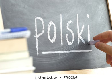 Hand writing on a blackboard in a language class with the word 