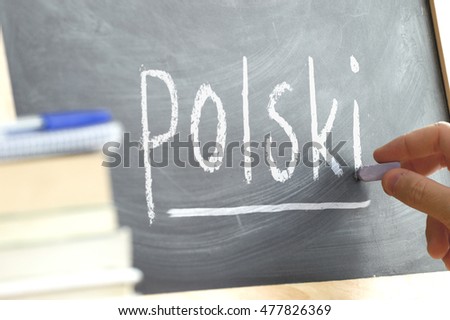 Hand writing on a blackboard in a language class with the word 