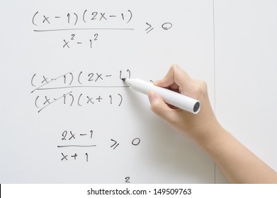 a hand writing on whiteboard