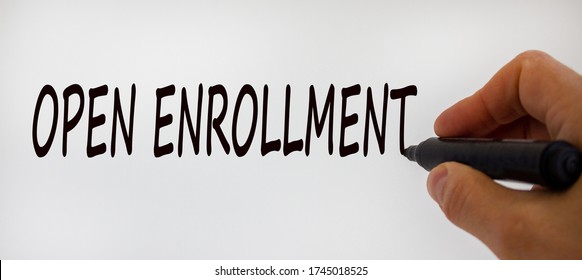 Hand writing 'open enrollment', isolated on beautiful white background. Concept.