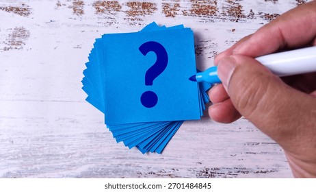 Hand Writing Question Mark: Stack of Blue Sticky Notes with Marker Pen
