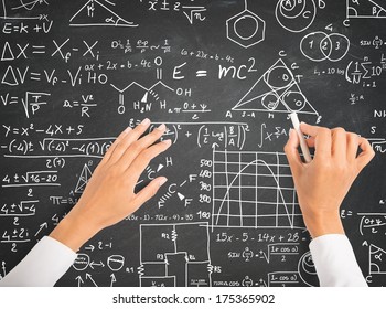 Hand writing science and math formulas on chalkboard