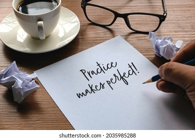 A Hand Writing Sentence ' Practice Makes Perfect ' Together With Glasses, Trash Paper, And A Cup Of Coffee On A Wooden Background.