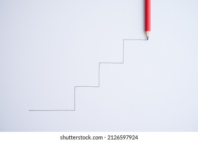 Hand Writing As Step Staircase Growing Up Continue To Target On White Paper Background With Copy Space. Business, Education Or Career Goal Target Success Achievement, Continuous Improvement Concept.